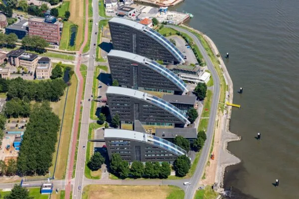 Luchtfoto van de Rivium Promenade met vier kenmerkende gebogen kantoorgebouwen langs de waterkant in Capelle aan den IJssel.